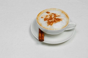 Cappuccino with cinnamon on white background