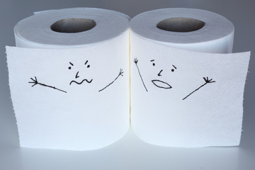 Two white toilet paper rolls sketched with an angry and a shouting face, close to each others, representing the rage and the panic feelings