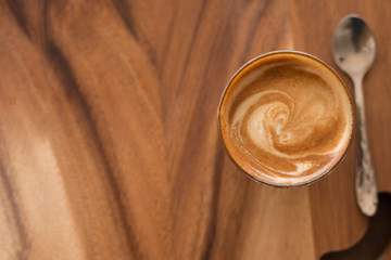 Piccolo Latte art in small glass on wooden desk