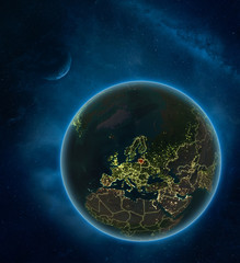 Lithuania at night from space with Moon and Milky Way. Detailed planet Earth with city lights and visible country borders.