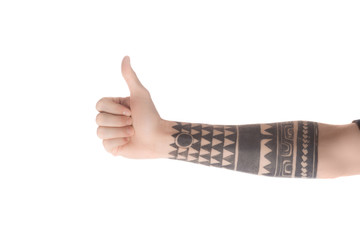 partial view of tattooed man showing thumb up sign isolated on white