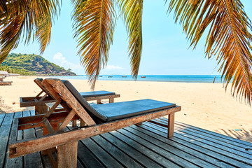 Fototapeta na wymiar beach lounger under coconut trees