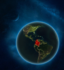 Colombia at night from space with Moon and Milky Way. Detailed planet Earth with city lights and visible country borders.