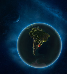Uruguay at night from space with Moon and Milky Way. Detailed planet Earth with city lights and visible country borders.