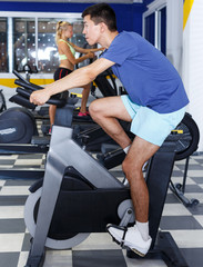 Fototapeta na wymiar athletic man working out on exercise bike