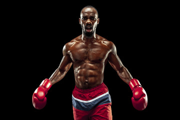 Fototapeta na wymiar Hands of boxer over black background. Strength, attack and motion concept. Fit african american model in movement. Afro muscular athlete in sport uniform. Sporty man during boxing