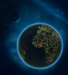 Ghana at night from space with Moon and Milky Way. Detailed planet Earth with city lights and visible country borders.