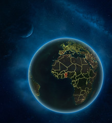 Benin at night from space with Moon and Milky Way. Detailed planet Earth with city lights and visible country borders.