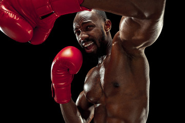 Hands of boxer over black background. Strength, attack and motion concept. Fit african american...