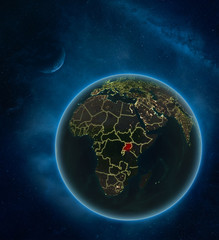 Uganda at night from space with Moon and Milky Way. Detailed planet Earth with city lights and visible country borders.