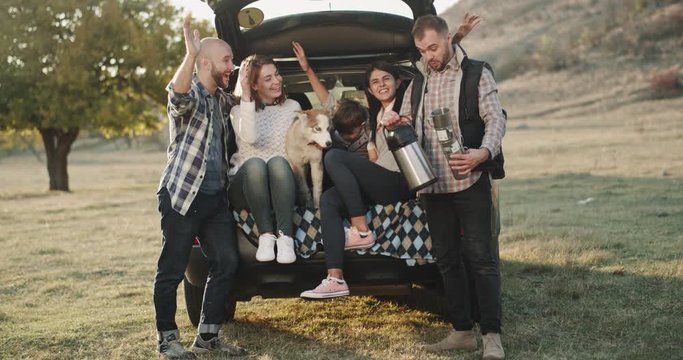 Happy Picnic Day Two Couple With A Beautiful Small Dog And Charismatic Small Boy , Spending A Good Time Sitting Of The Trunk Of The Car One Man Brings Some Cups And A Big Thermos With Tea. .4k