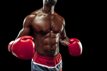 Fototapeta na wymiar Hands of boxer over black background. Strength, attack and motion concept. Fit african american model in movement. Afro muscular athlete in sport uniform. Sporty man during boxing