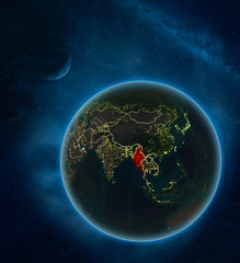 Myanmar at night from space with Moon and Milky Way. Detailed planet Earth with city lights and visible country borders.
