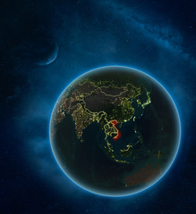 Vietnam at night from space with Moon and Milky Way. Detailed planet Earth with city lights and visible country borders.