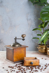 Old wooden coffee grinder on concrete background.