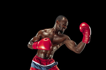 Hands of boxer over black background. Strength, attack and motion concept. Fit african american model in movement. Afro muscular athlete in sport uniform. Sporty man during boxing