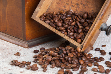 Old wooden coffee grinder on concrete background.
