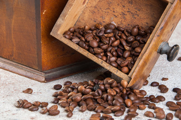 Old wooden coffee grinder on concrete background.