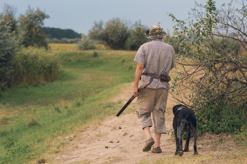 Hunter with a german drathaar and spaniel, pigeon hunting with dogs in reflective vests