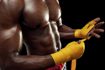 Obraz premium Afro American boxer is wrapping hands with yellow bandage