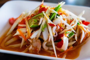 Papaya salad with shrimp and octopus, Traditional spicy Thai food.