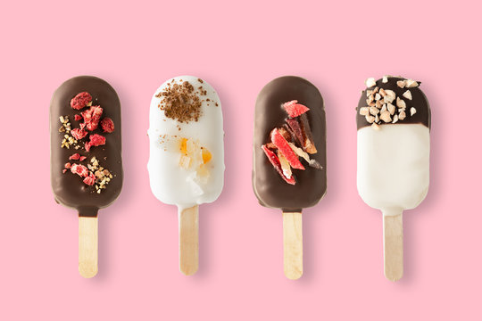 Different variants of cake popsice creams on pink background