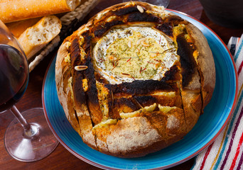 Cheese fondue from camembert in bread bowl
