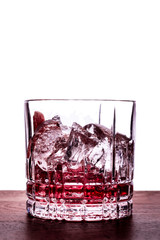 Red Cocktail with ice on wooden table isolated on white background