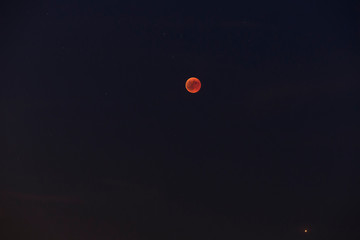 a panorama of a lunar eclipse or red moon next to Mars
