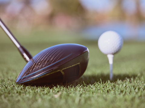 Golf club driver near ball on grass