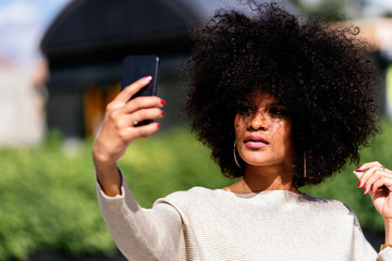 Fototapeta na wymiar Portrait of attractive afro woman taking selfie portrait