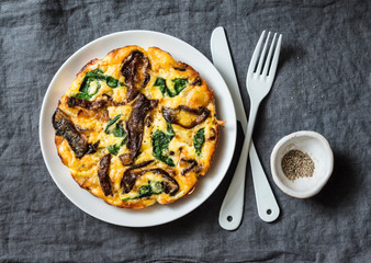 Porcini mushrooms, potatoes, spinach baked frittata - delicious breakfast, snack, tapas on a gray...