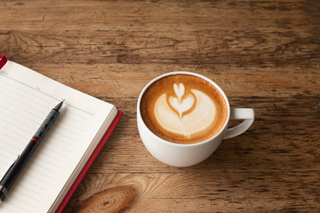 Top view Note book with pencil, and a cup of coffee on wood table for Business background