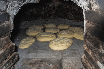 Photograph of how homemade bread is made in a wood-burning oven.
