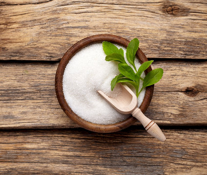 Stevia rebaudiana, sweet leaf sugar substitute isolated in wooden bowl on wooden background