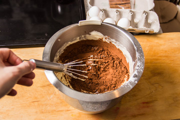 Iron bowl with dough in which the whisk mix the ingredients