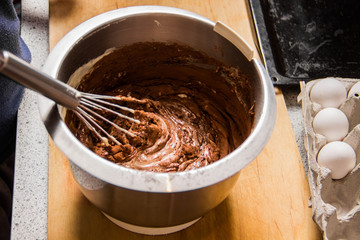 Iron bowl with dough in which the whisk mix the ingredients
