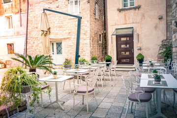 Fototapeta na wymiar Mediterranean cafe terrace on an old street in ancient town