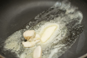 Melting butter with garlic in a pan.