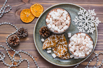 Dried mandarin slices, hot cocoa with marshmallows and christmas cookies on the table in Christmas decorations. Top view
