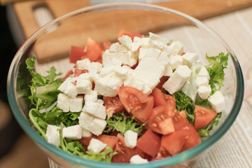 Cooking salad from fresh vegetables and cheese.
