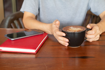 A woman is holding a  coffee cup in coffee's shop.