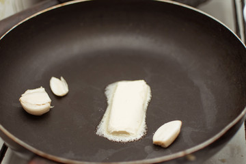 Melting butter with garlic in a pan.
