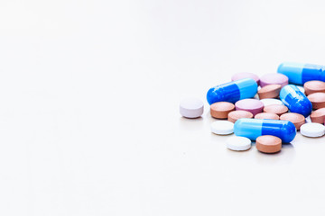 Medications of various colors on a light background. Space for text.