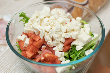 Cooking salad from fresh vegetables and cheese.