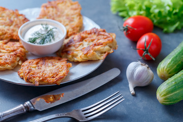 Draniki - potato fritters. potato pancakes lie on a plate. The national dish of Belarus, Ukraine, Russia.