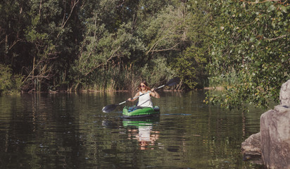 Fototapeta na wymiar Young woman kayaking on the lake