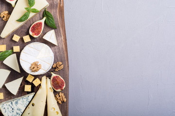 Cheeseboard with cheese brie , parmesan , camembert and dorblu . Food on wooden board