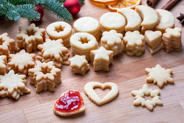 Obraz na płótnie Canvas Filling Linzer Christmas cookies with strawberry marmalade