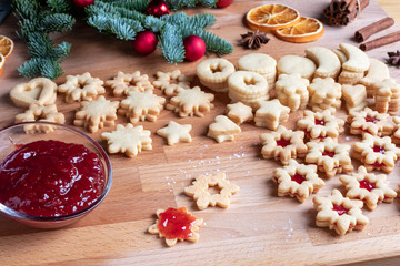 Filling traditional Linzer Christmas cookies with strawberry marmalade